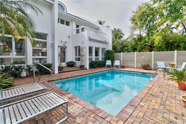 view of swimming pool featuring a patio area, fence, and a fenced in pool