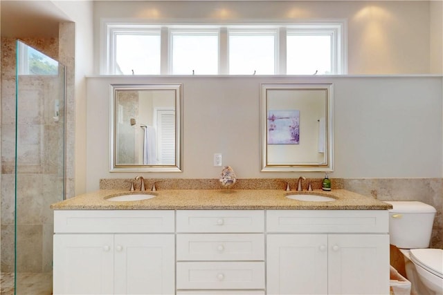 full bath with a tile shower, a sink, and toilet