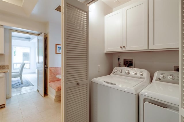 washroom featuring light tile patterned floors, washing machine and dryer, and cabinet space