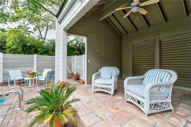 view of patio with fence and a ceiling fan