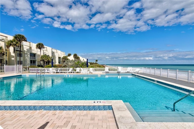 pool featuring a water view and fence