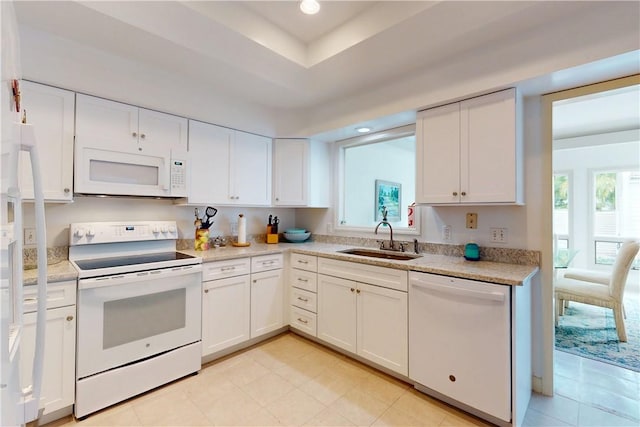 kitchen with light countertops, white appliances, white cabinets, and a sink