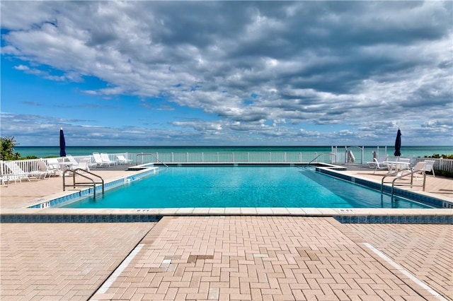 pool with a water view and a patio