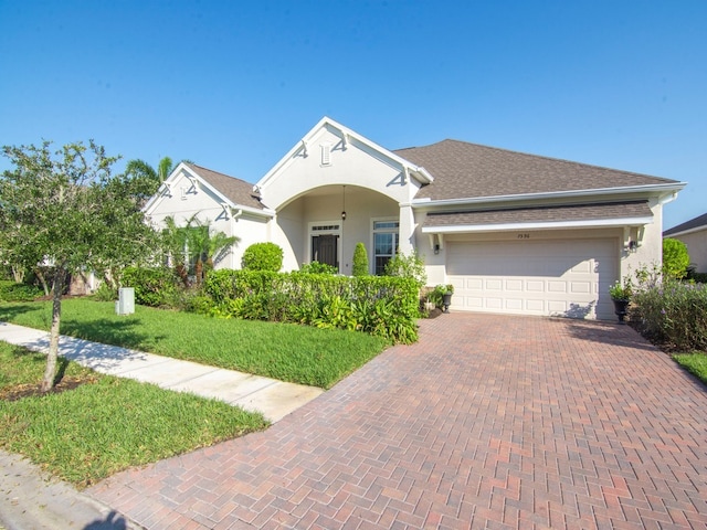 single story home with a garage and a front lawn