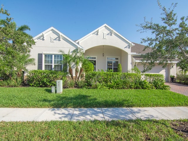 view of front of home with a garage and a front lawn