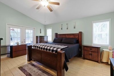 bedroom with french doors, ceiling fan, lofted ceiling, and light hardwood / wood-style flooring