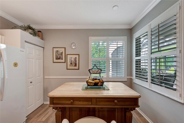 dining room with light hardwood / wood-style flooring and crown molding