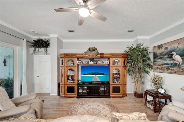 living room featuring ceiling fan, light hardwood / wood-style floors, ornamental molding, and a textured ceiling