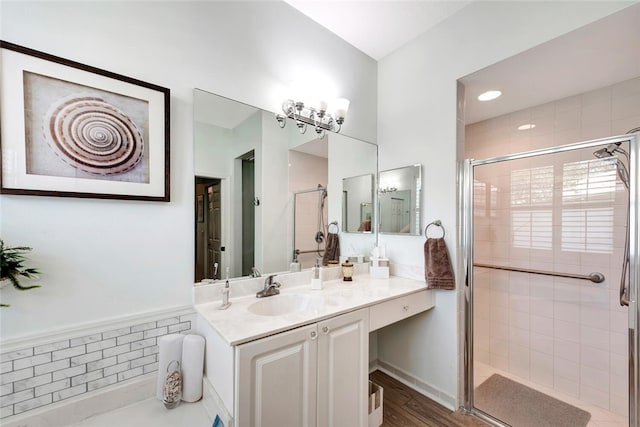 bathroom with hardwood / wood-style floors, vanity, and a shower with door