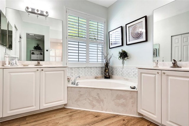 bathroom featuring vanity, hardwood / wood-style flooring, and a tub