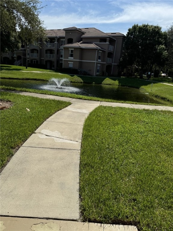 surrounding community featuring a water view and a yard