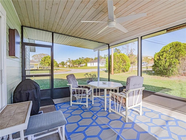 sunroom featuring ceiling fan and wood ceiling