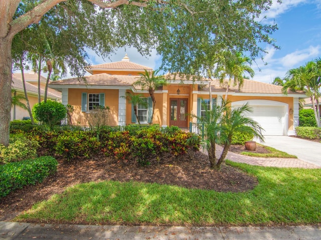 9082 Castle Harbour Cir, Vero Beach, FL 32963 - view of front of home with driveway, a garage, stucco siding, and french doors