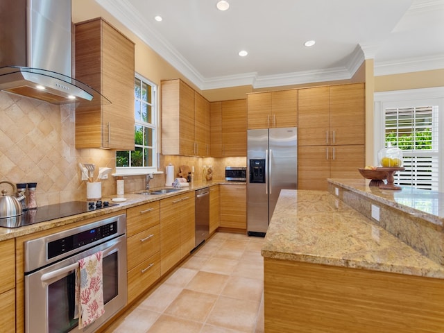 kitchen featuring plenty of natural light, wall chimney range hood, light stone countertops, and stainless steel appliances