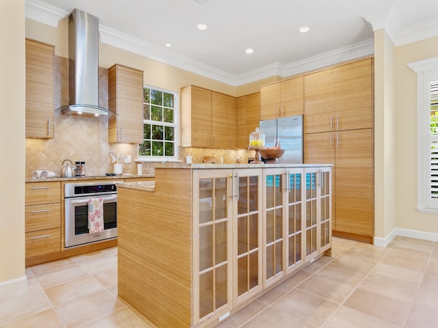 9082 Castle Harbour Cir, Vero Beach, FL 32963 - kitchen with appliances with stainless steel finishes, wall chimney exhaust hood, a center island, backsplash, and crown molding