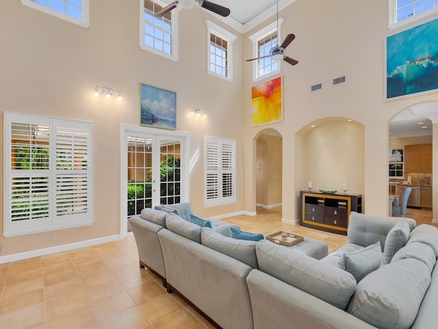 9082 Castle Harbour Cir, Vero Beach, FL 32963 - living room with ceiling fan, arched walkways, a towering ceiling, crown molding, and light tile patterned floors