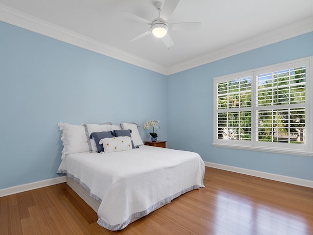 bedroom featuring hardwood / wood-style flooring, ceiling fan, and crown molding