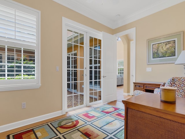 office featuring light hardwood / wood-style floors, french doors, a healthy amount of sunlight, and crown molding