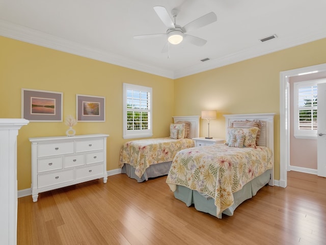 bedroom featuring light hardwood / wood-style floors, ceiling fan, and crown molding