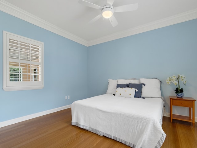 bedroom with dark hardwood / wood-style flooring, ceiling fan, and crown molding