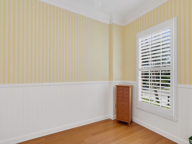 9082 Castle Harbour Cir, Vero Beach, FL 32963 - unfurnished room featuring wallpapered walls, wainscoting, wood finished floors, and ornamental molding