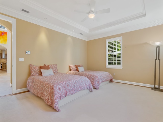 bedroom featuring ornamental molding, light colored carpet, ceiling fan, and a raised ceiling