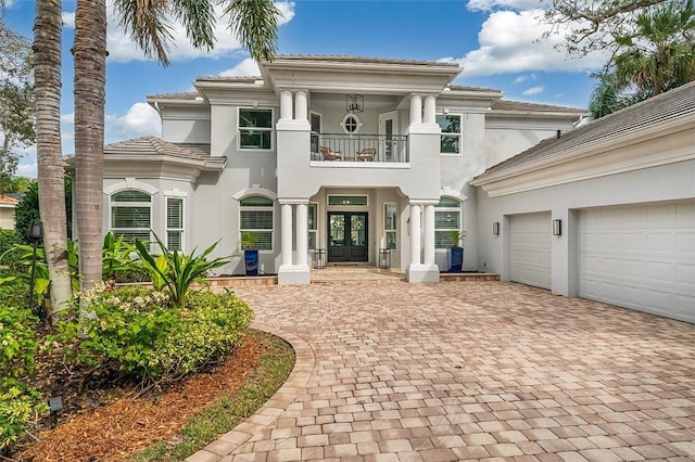 view of front facade with french doors, a balcony, and a garage