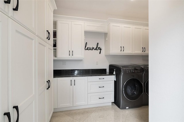 laundry room with cabinets, light tile patterned flooring, and washer and clothes dryer