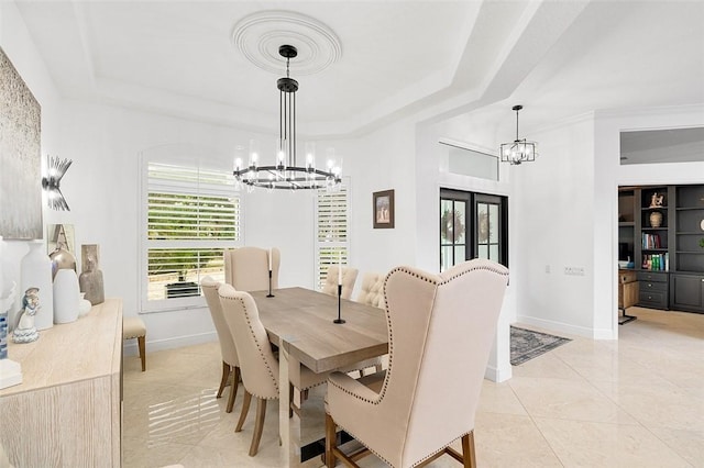 tiled dining area featuring a raised ceiling and a chandelier