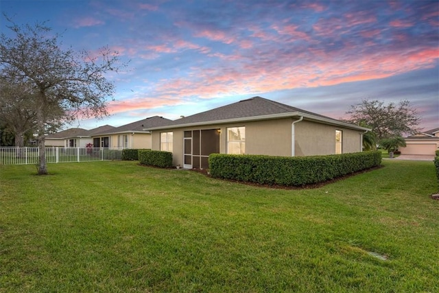 property exterior at dusk with a yard