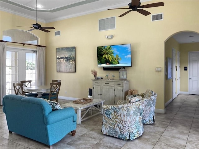 living room featuring a high ceiling, crown molding, and ceiling fan