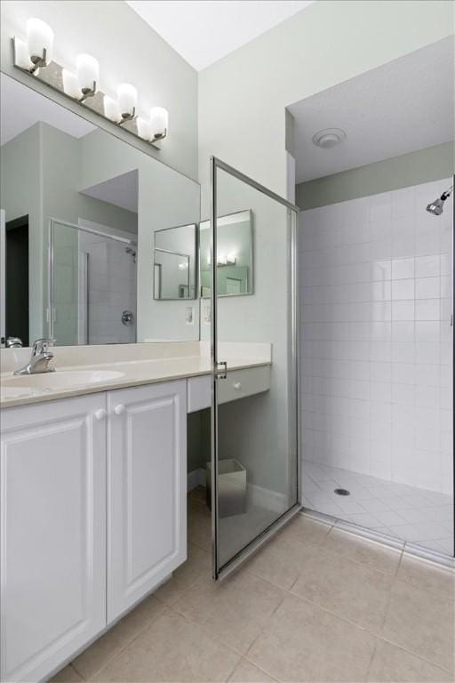 bathroom with vanity, a shower with shower door, and tile patterned floors