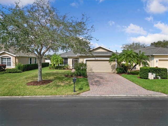 ranch-style house with a garage and a front lawn