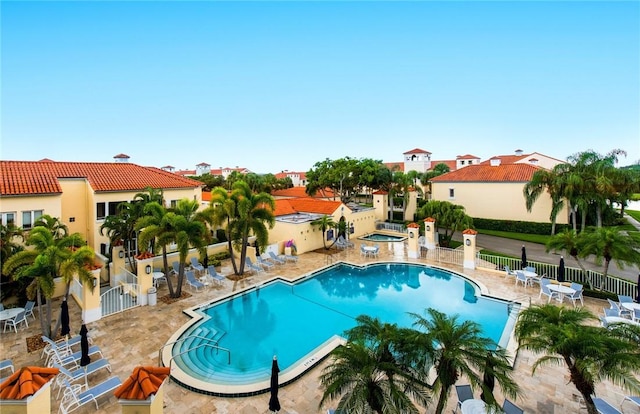 5075 Harmony Cir Unit 302, Vero Beach, FL 32967 - community pool featuring a patio area, a hot tub, and a residential view