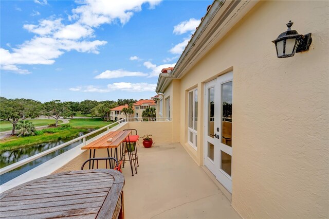 view of patio / terrace featuring a water view and a balcony