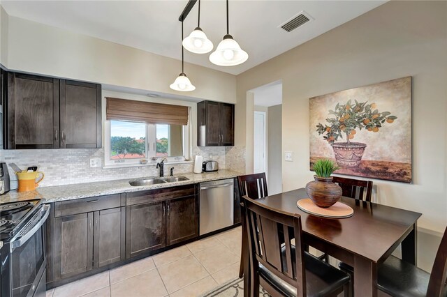 kitchen with stainless steel appliances, sink, tasteful backsplash, light stone countertops, and pendant lighting