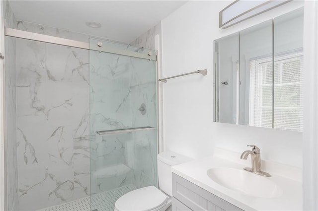 bathroom featuring vanity, toilet, and a shower with shower door