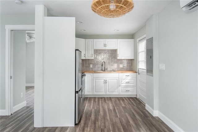 kitchen with dark wood-type flooring, wood counters, white cabinetry, and sink