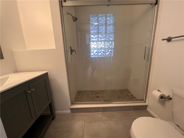 bathroom featuring walk in shower, tile patterned flooring, vanity, and toilet