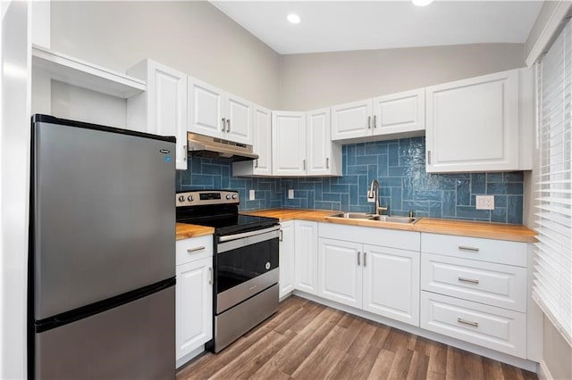 kitchen with white cabinetry, appliances with stainless steel finishes, wood counters, decorative backsplash, and sink