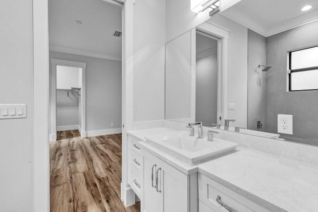 bathroom with crown molding, vanity, and hardwood / wood-style flooring