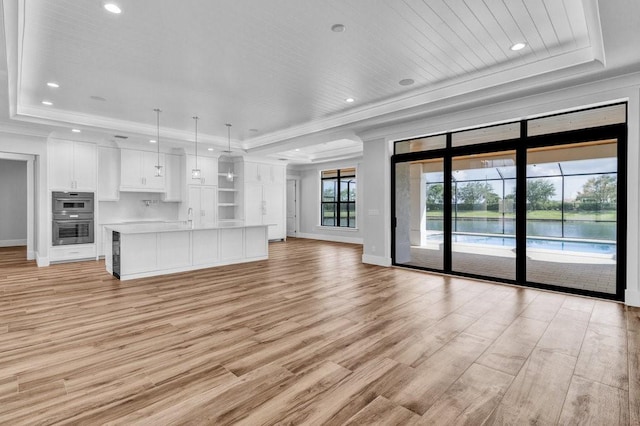 unfurnished living room featuring sink, crown molding, wood ceiling, light hardwood / wood-style flooring, and a raised ceiling