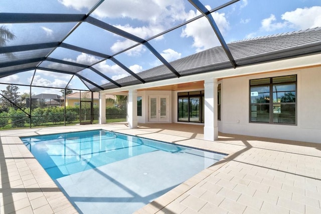 view of swimming pool featuring a lanai, a patio area, and french doors