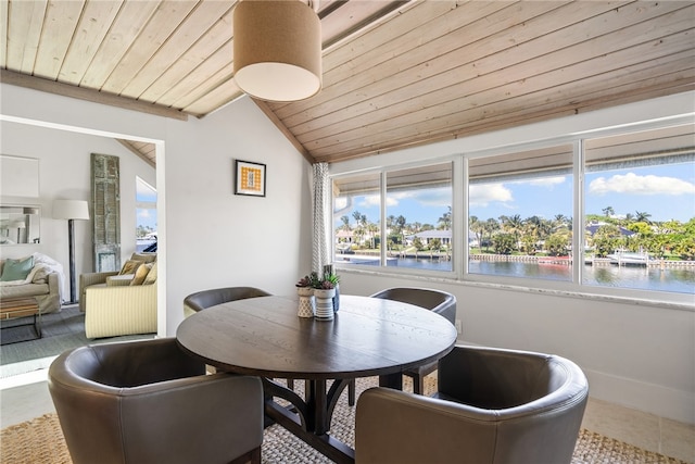 dining room with a water view, vaulted ceiling, tile patterned flooring, and wooden ceiling