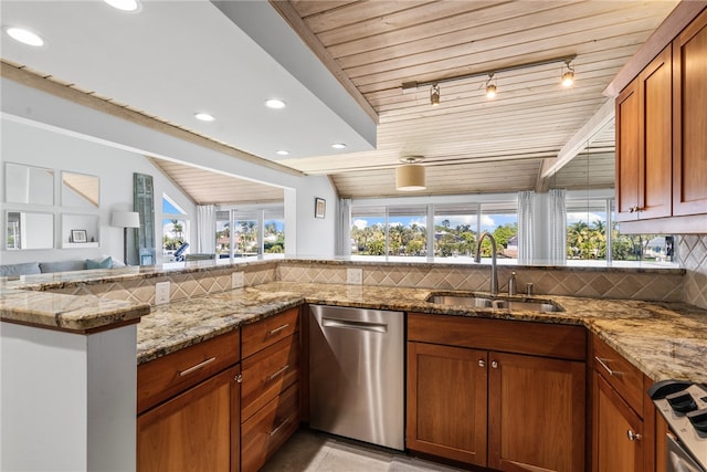 kitchen with a wealth of natural light, stainless steel appliances, light stone counters, and backsplash