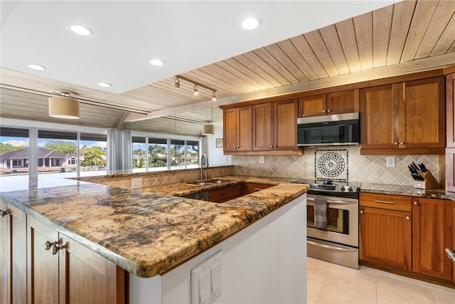 kitchen featuring sink, rail lighting, light tile patterned flooring, light stone countertops, and appliances with stainless steel finishes