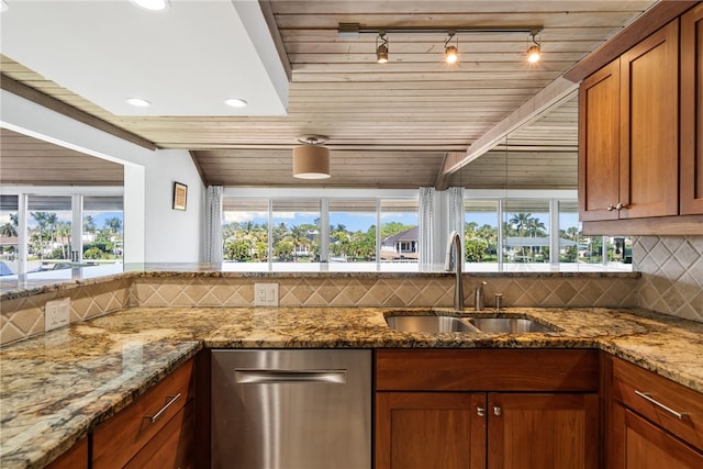 kitchen with stone counters, sink, track lighting, and decorative backsplash