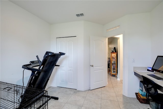 exercise room with light tile patterned flooring