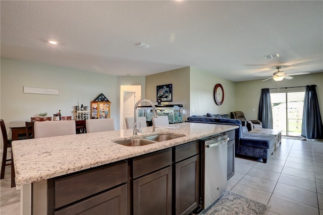 kitchen with a center island with sink, a textured ceiling, sink, stainless steel dishwasher, and ceiling fan