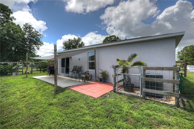 rear view of house featuring a lawn and a patio area